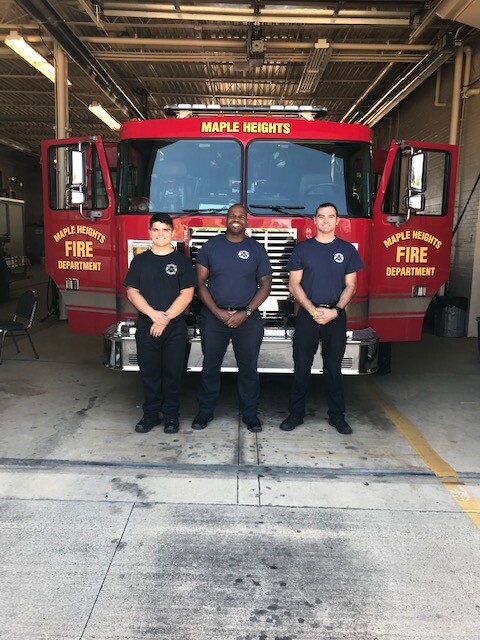 3 new Fire Department cadets standing in front of a Maple Heights fire engine